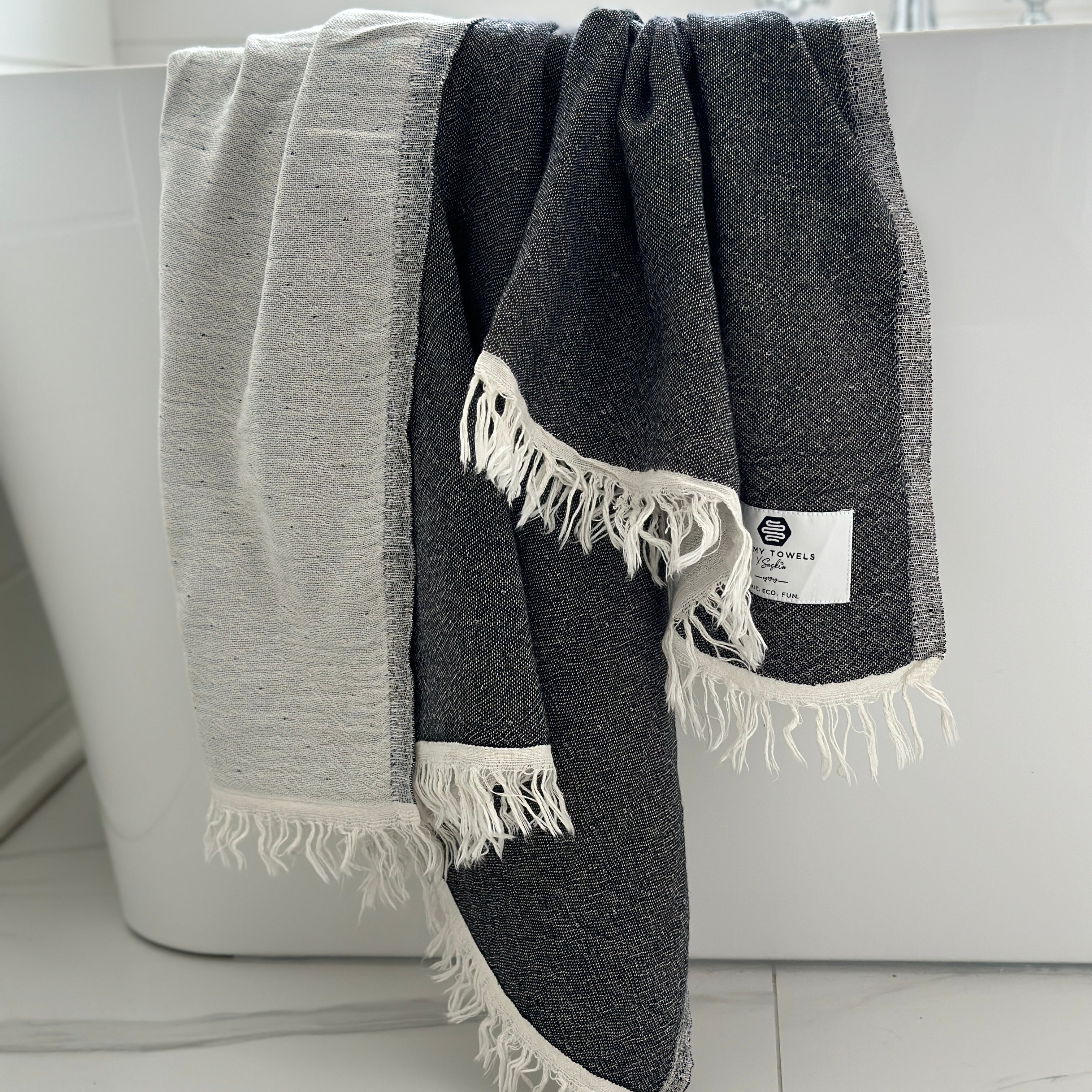 Our beautiful Napoli Towel in black on the side of the bathtub
