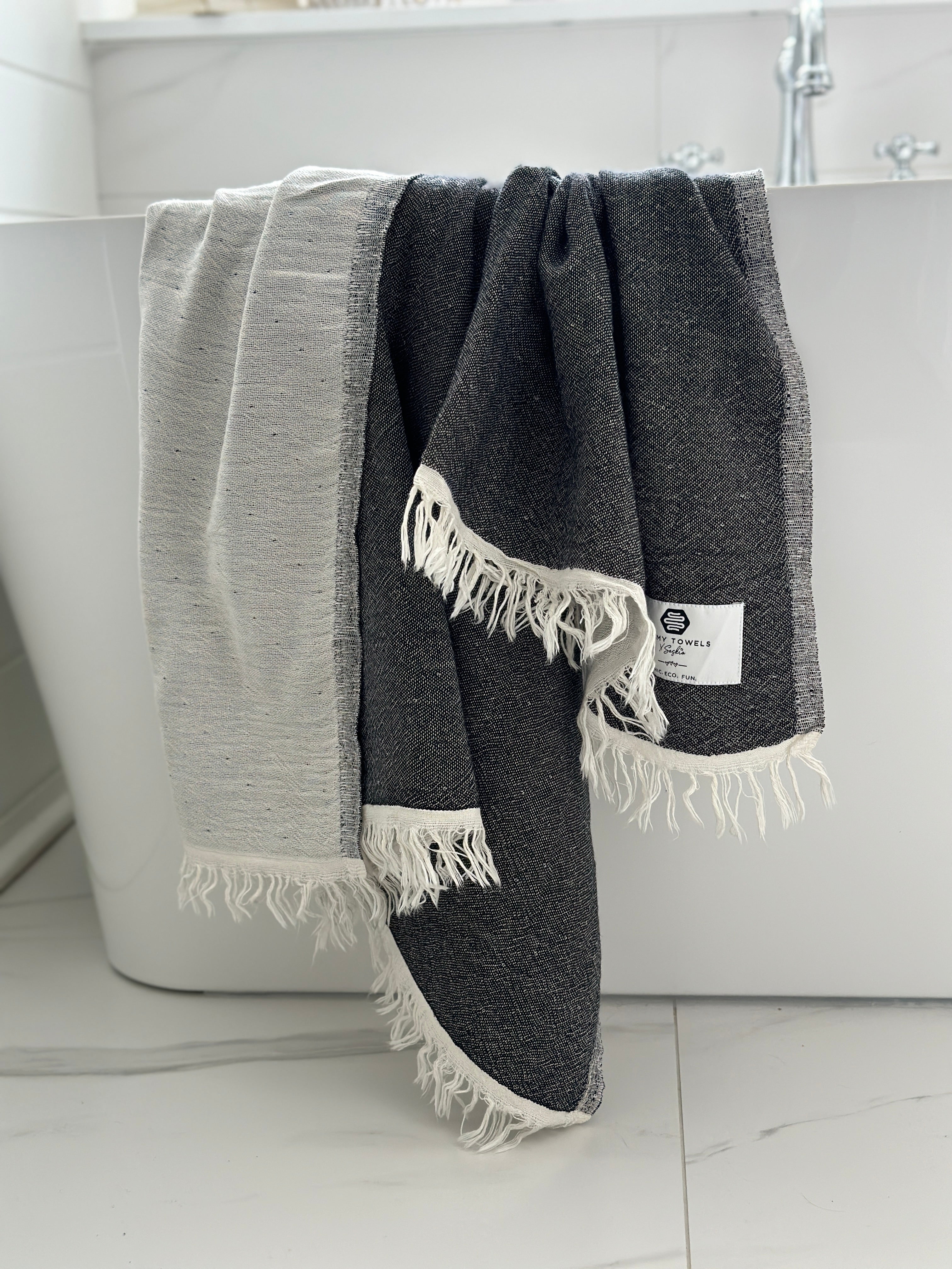 Our beautiful Napoli Towel in black on the side of the bathtub