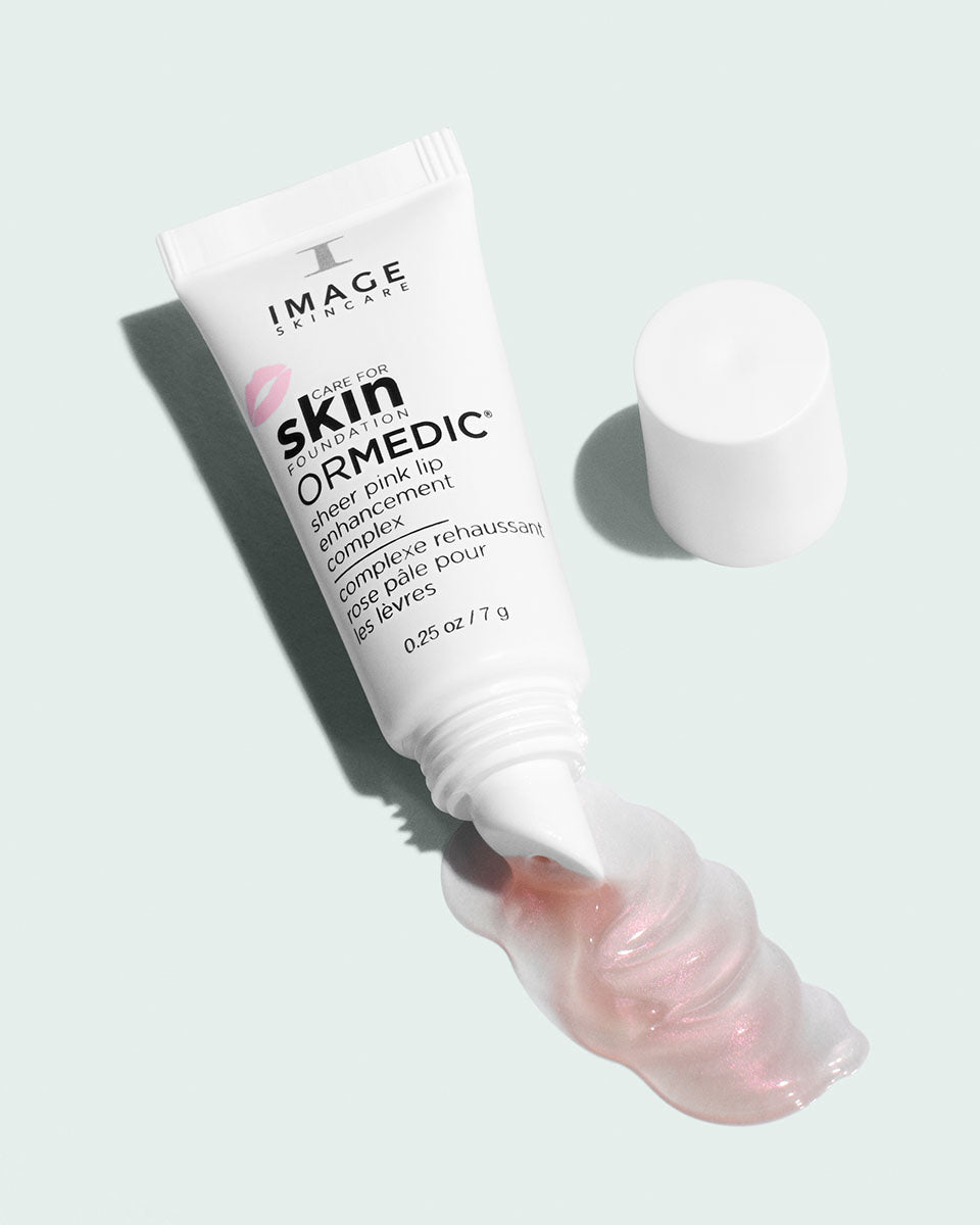 Tube ORMEDIC rose pâle pour les lèvres d’Image Skincare ouvert, bouchon à côté, filet de gloss rose nacré
