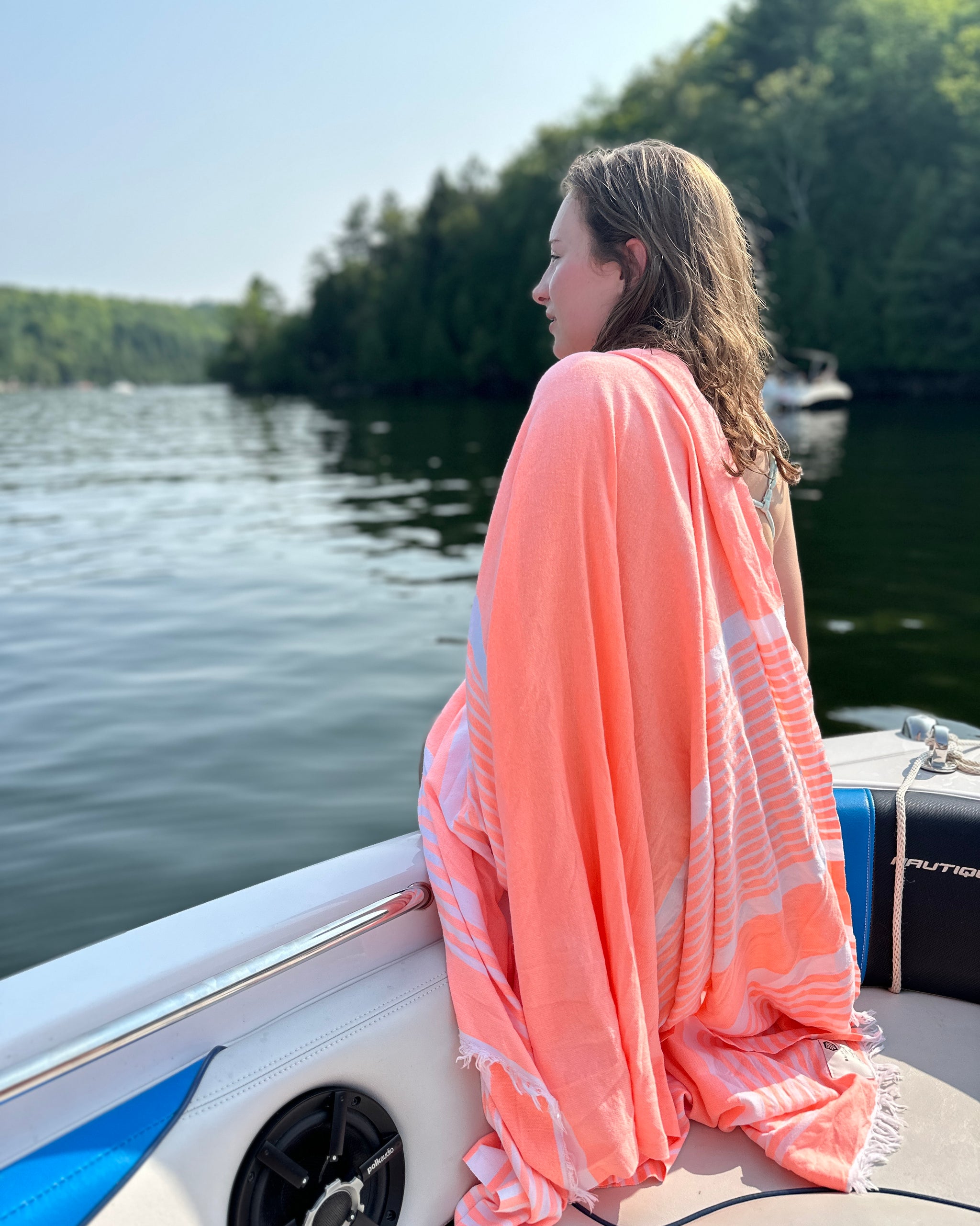Une femme sur un bateau, enveloppée dans une serviette Bonbon rose