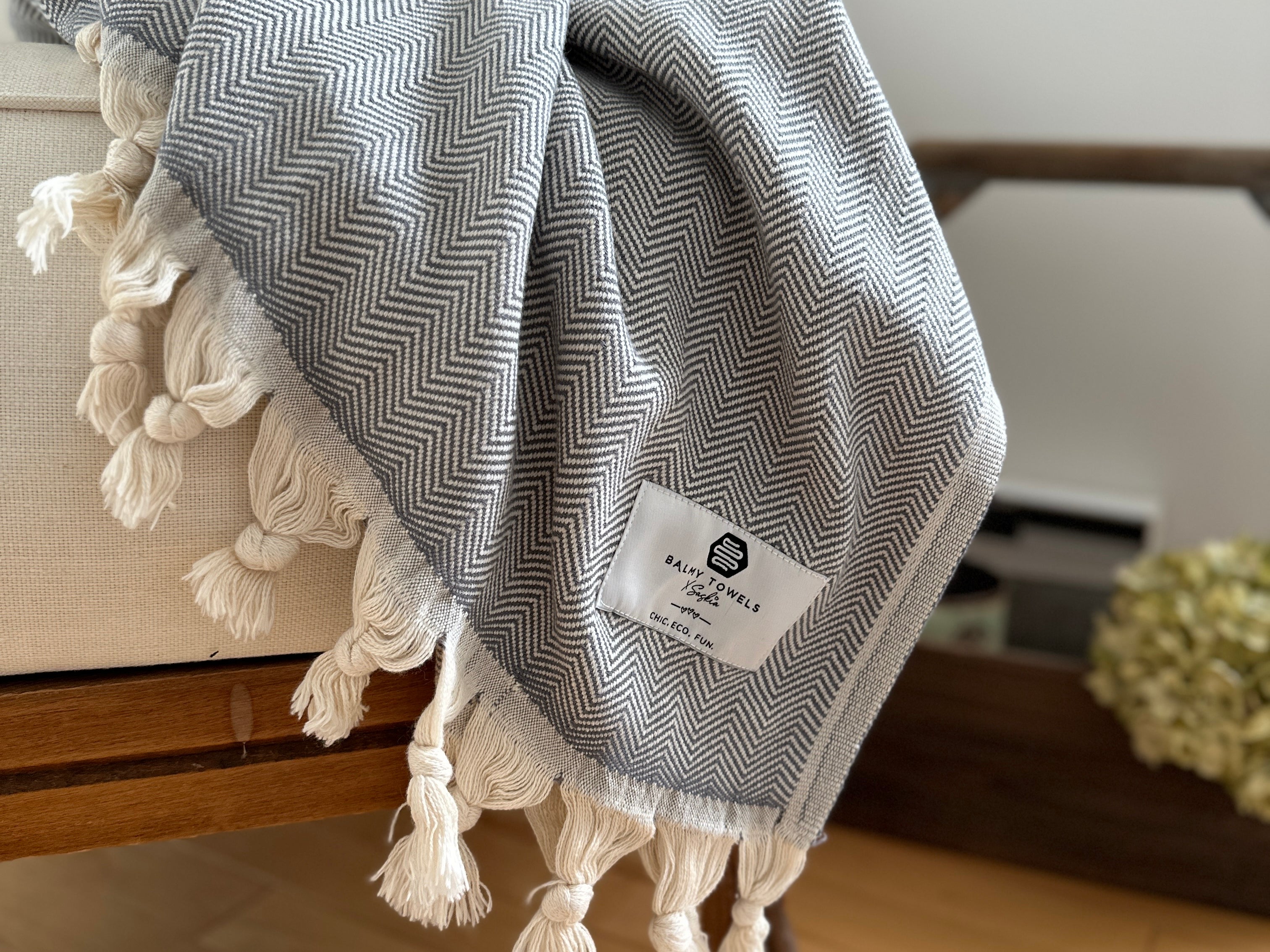 Chevron cotton throw folded on a couch – elegant, soft, and timeless