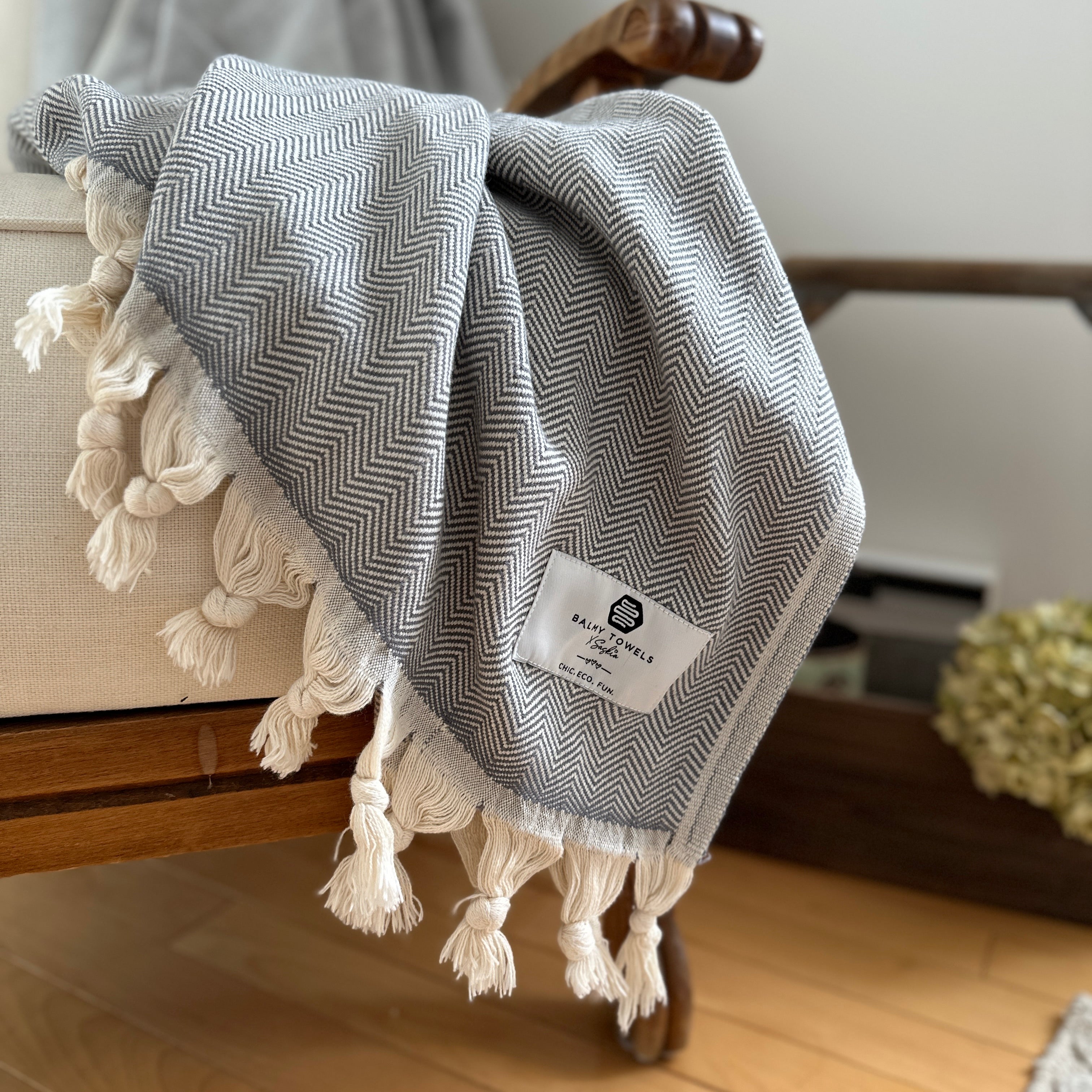 Chevron cotton throw folded on a couch – elegant, soft, and timeless