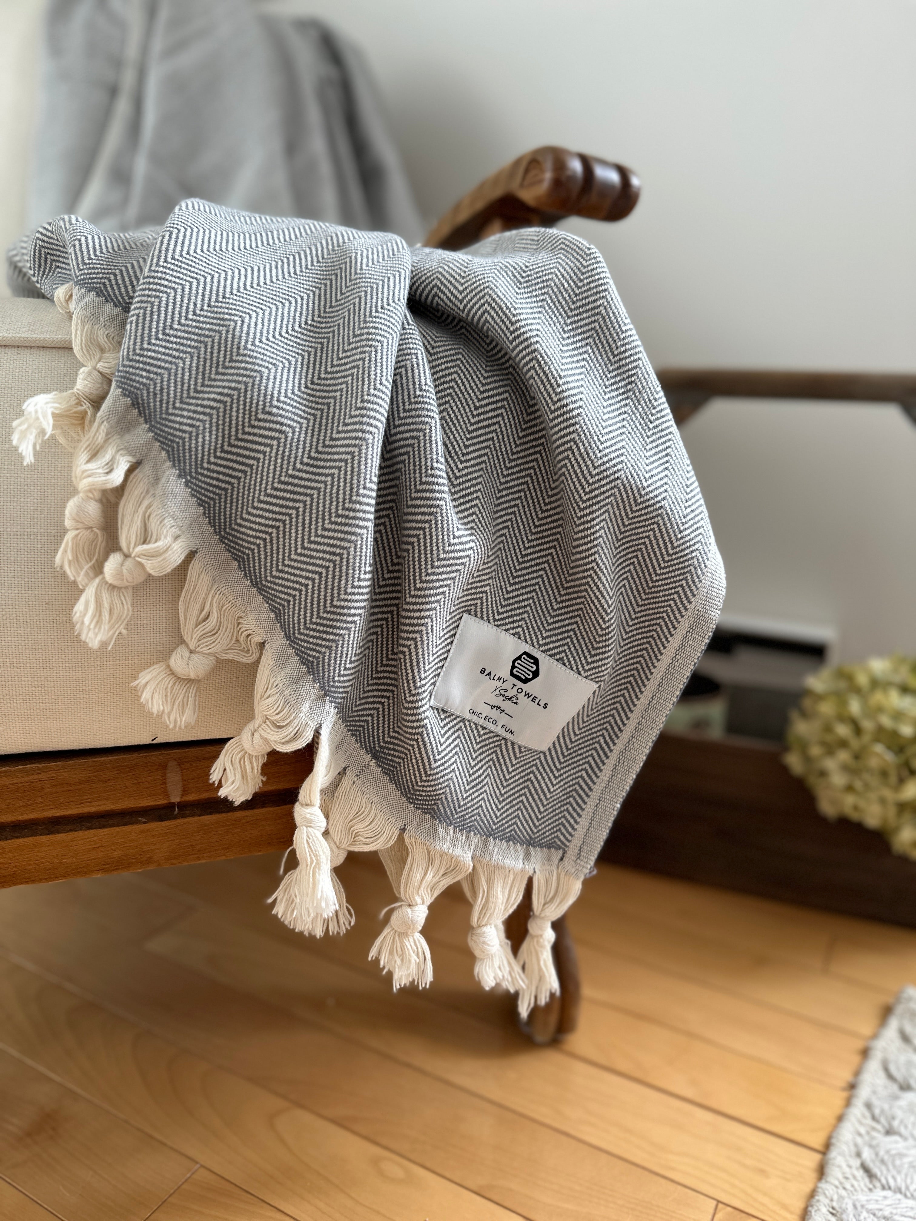 Chevron cotton throw folded on a couch – elegant, soft, and timeless