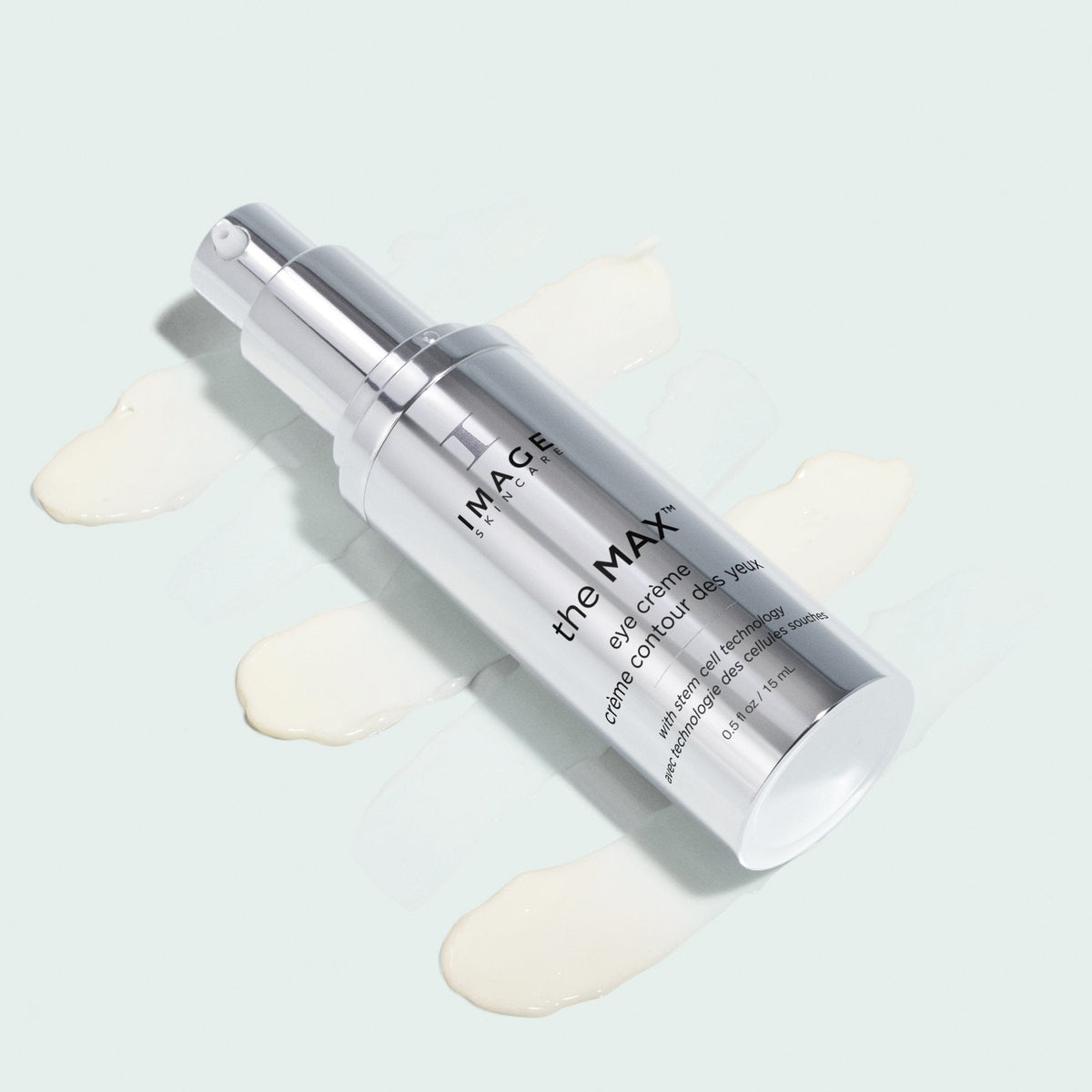 Silver Image Skincare the MAX eye crème bottle lying on swatches of ivory cream, pale background