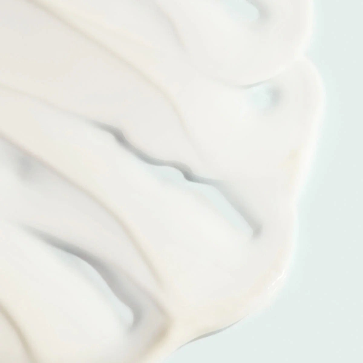 Close-up of the white creamy texture of Image Skincare VITAL C hydrating anti-aging serum, pale background