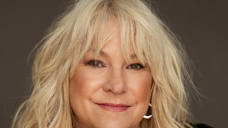 Portrait de la chanteuse Lulu Hughes, souriante, aux longs cheveux blonds